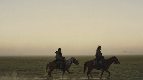 Two riders at dawn on the Mongolian steppe