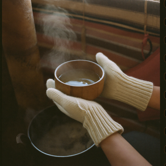 Ribbed Cashmere Mittens holding a bowl of tea